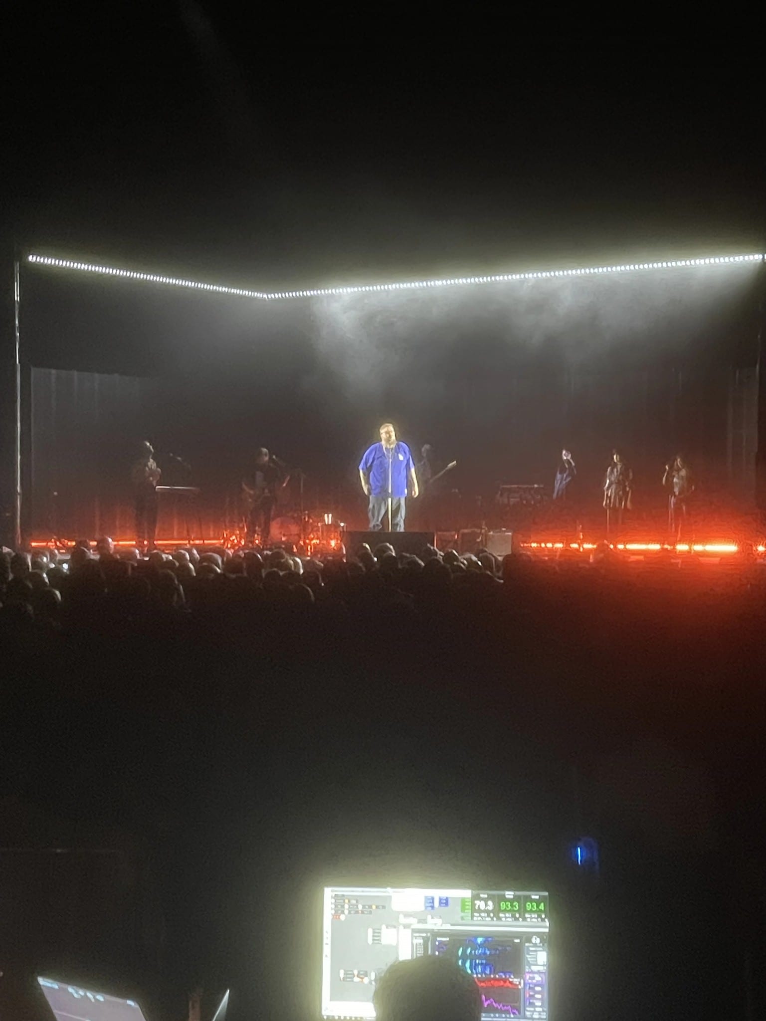 Show look: white LED ceiling, singer in blue, media-server desk in the foreground, Rag'n'Bone Man 2024 UK and EU tour.