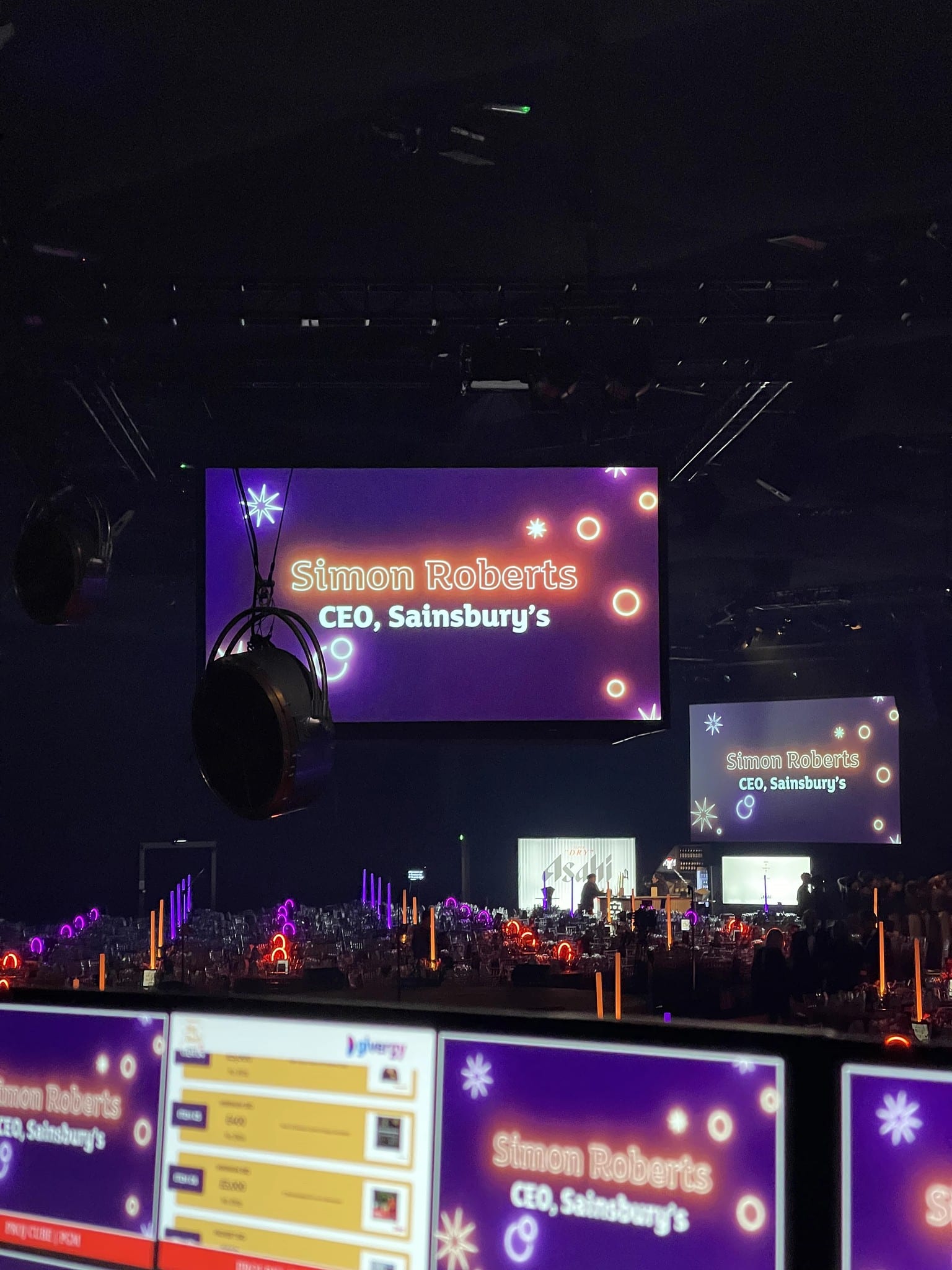 House screens and booth monitors showing Simon Roberts, CEO, Sainsbury's, Big Bash, Evolution London, December 2025.